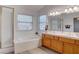 Bright bathroom featuring a soaking tub, dual-sink vanity, and ample natural light at 1270 Del Lilly Ln, Las Vegas, NV 89123