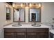 Contemporary bathroom features dual sinks, quartz countertops, and custom mirrors with wood detail at 1657 Hartley Ave, Henderson, NV 89052
