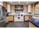 Charming kitchen with custom cabinetry, designer tile accents, and stainless steel appliances at 1657 Hartley Ave, Henderson, NV 89052