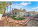 Backyard view of the home showing patio seating, lounge chairs, and desert landscaping at 1808 Scenic Sunrise Dr, Las Vegas, NV 89117