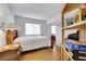 Simple bedroom with wooden bed frame, striped comforter, and small bedside table at 1808 Scenic Sunrise Dr, Las Vegas, NV 89117