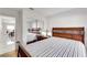 Bedroom with light-striped bedding, mirrored closet and a hardwood floor at 1808 Scenic Sunrise Dr, Las Vegas, NV 89117