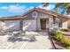 Inviting single-story home featuring a two-car garage, arched entryway, and tidy landscaping at 1808 Scenic Sunrise Dr, Las Vegas, NV 89117