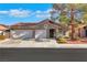 Charming home featuring a two-car garage, tiled roof, and lovely front yard landscaping at 1808 Scenic Sunrise Dr, Las Vegas, NV 89117