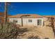Rear exterior of home with windows and a sliding glass door, overlooking a spacious gravel backyard at 186 Shaded Peak St, Henderson, NV 89012