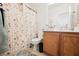 Well-lit bathroom featuring a classic vanity, toilet, and shower with decorative curtain at 186 Shaded Peak St, Henderson, NV 89012