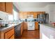 Bright kitchen with stainless steel refrigerator, wood cabinets, sink and dishwasher at 186 Shaded Peak St, Henderson, NV 89012