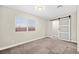 Cozy bedroom with carpet flooring, large window, and modern sliding door at 19 Montana Way, Henderson, NV 89015
