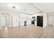 Open concept kitchen with white cabinets, stainless steel appliances, and wood-look floors at 19 Montana Way, Henderson, NV 89015