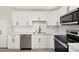 Well-lit kitchen featuring white cabinets, stainless steel appliances, and modern fixtures at 19 Montana Way, Henderson, NV 89015