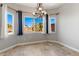 Bright dining area with decorative chandelier and views of the landscaped yard from the large windows at 2276 Laramine River Dr, Henderson, NV 89052
