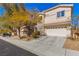 Inviting two-story home showcasing a three-car garage, mature trees, and tidy landscaping at 2276 Laramine River Dr, Henderson, NV 89052