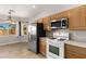 Bright kitchen features stainless steel refrigerator, white appliances, and a view from the dining area window at 2276 Laramine River Dr, Henderson, NV 89052
