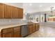 Well-appointed kitchen with stainless steel dishwasher, wooden cabinets, and stone tile flooring at 2276 Laramine River Dr, Henderson, NV 89052