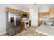 Well-lit kitchen features stainless steel refrigerator, white appliances, and beautiful stone tile flooring at 2276 Laramine River Dr, Henderson, NV 89052