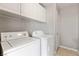 Laundry room with white washer and dryer and storage cabinets above at 2276 Laramine River Dr, Henderson, NV 89052