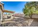 The backyard with gravel landscaping, a covered patio, block wall, and mature shade tree at 427 Mindoro Ave, North Las Vegas, NV 89031