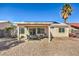 View of the backyard showing patio area, rock landscaping, and mature palm tree at 427 Mindoro Ave, North Las Vegas, NV 89031