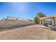 Large backyard featuring gravel, block wall, and covered patio area at 427 Mindoro Ave, North Las Vegas, NV 89031
