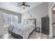 Comfortable bedroom featuring a cozy bed, ceiling fan, and large window with natural light at 427 Mindoro Ave, North Las Vegas, NV 89031