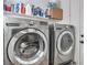 Modern laundry room featuring front loading washer and dryer set with storage shelf at 427 Mindoro Ave, North Las Vegas, NV 89031