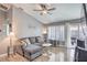 Relaxing living room with a plush gray sofa, hardwood floors, and natural light from the windows at 427 Mindoro Ave, North Las Vegas, NV 89031