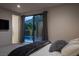 Modern bedroom with plush bedding, TV, and sliding glass doors with backyard and pool views at 438 Serenity Point Dr, Henderson, NV 89012