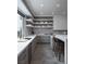 Modern kitchen with gray cabinets, white countertops, floating shelves, and stainless steel appliances at 438 Serenity Point Dr, Henderson, NV 89012