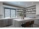 Modern kitchen with a waterfall island and sleek countertops, and an abundance of storage and shelving at 438 Serenity Point Dr, Henderson, NV 89012