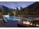 Modern pool with waterfall feature, relaxing lounge chairs, and an inviting outdoor fireplace at 438 Serenity Point Dr, Henderson, NV 89012