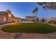Lush backyard featuring artificial turf, desert landscaping, and a sparkling in-ground pool with a slide at 4690 Designer Way, Las Vegas, NV 89129