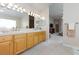 Bathroom vanity featuring double sinks, wooden cabinets, and a bright mirror above, adding a touch of warmth at 4690 Designer Way, Las Vegas, NV 89129