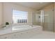 Bathroom featuring a separate jacuzzi tub and glass-enclosed shower with tile surround at 4690 Designer Way, Las Vegas, NV 89129