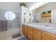 Well-lit bathroom featuring a shower-tub combination, double sinks, and ample storage with wooden cabinets at 4690 Designer Way, Las Vegas, NV 89129