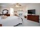 Primary bedroom with ceiling fan, sitting area, dresser, and access to outdoor patio at 4690 Designer Way, Las Vegas, NV 89129
