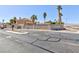Community entrance, with a decorative stone wall and mature palm trees, offers security at 4690 Designer Way, Las Vegas, NV 89129