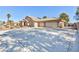 Expansive driveway leading to a home with a three-car garage and desert landscaping, enhancing curb appeal at 4690 Designer Way, Las Vegas, NV 89129