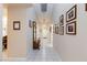 Inviting hallway with tiled flooring, light walls adorned with framed pictures, and a decorative bench at 4690 Designer Way, Las Vegas, NV 89129