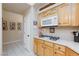 Bright kitchen featuring tile floors, gas stovetop, wood cabinets, and modern microwave at 4690 Designer Way, Las Vegas, NV 89129