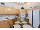 Eat-in kitchen featuring white appliances, wood cabinets, tile floors, and breakfast nook at 4690 Designer Way, Las Vegas, NV 89129