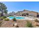 Backyard oasis featuring a sparkling pool, spa, lush landscaping, and a covered patio at 4690 Designer Way, Las Vegas, NV 89129