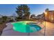 Sparkling pool and spa with slide, enhanced by evening lighting creating an inviting outdoor oasis at 4690 Designer Way, Las Vegas, NV 89129