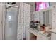 Bathroom featuring a stand up shower and vanity with Hollywood style lighting and vanity mirror at 4705 Blaise Ave # 101, North Las Vegas, NV 89084