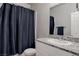 Bathroom featuring a shower/tub combo, gray granite vanity top, and simple design at 4705 Blaise Ave # 101, North Las Vegas, NV 89084