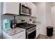The kitchen boasts granite countertops, stainless steel oven, and a microwave at 4705 Blaise Ave # 101, North Las Vegas, NV 89084