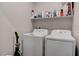 Laundry room with a modern washer and dryer, and shelving for storage of cleaning supplies at 4705 Blaise Ave # 101, North Las Vegas, NV 89084