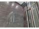 Contemporary shower design with gray textured tile, a rainfall shower head and glass door at 556 Caribbean Palm Dr, Las Vegas, NV 89138