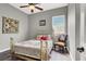 Cozy bedroom with a brass bed frame, a ceiling fan, and a window for natural light at 6392 Ebony Legends Ave, Las Vegas, NV 89131