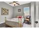 Cozy bedroom with a brass bed frame, a ceiling fan, and a window for natural light at 6392 Ebony Legends Ave, Las Vegas, NV 89131