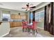 Inviting breakfast nook features a ceiling fan, large windows, and a round glass table with pink chairs at 6392 Ebony Legends Ave, Las Vegas, NV 89131